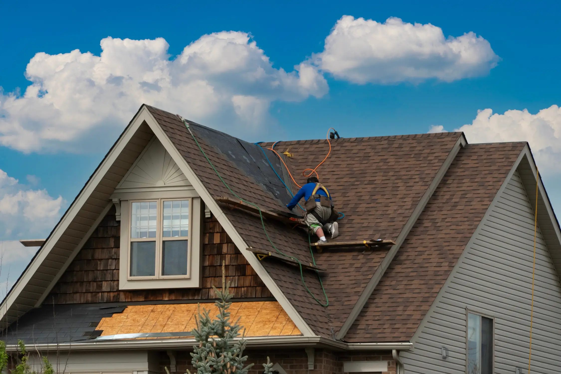 Roof repair in progress on a residential home by WOW Roofing & Gutters.
