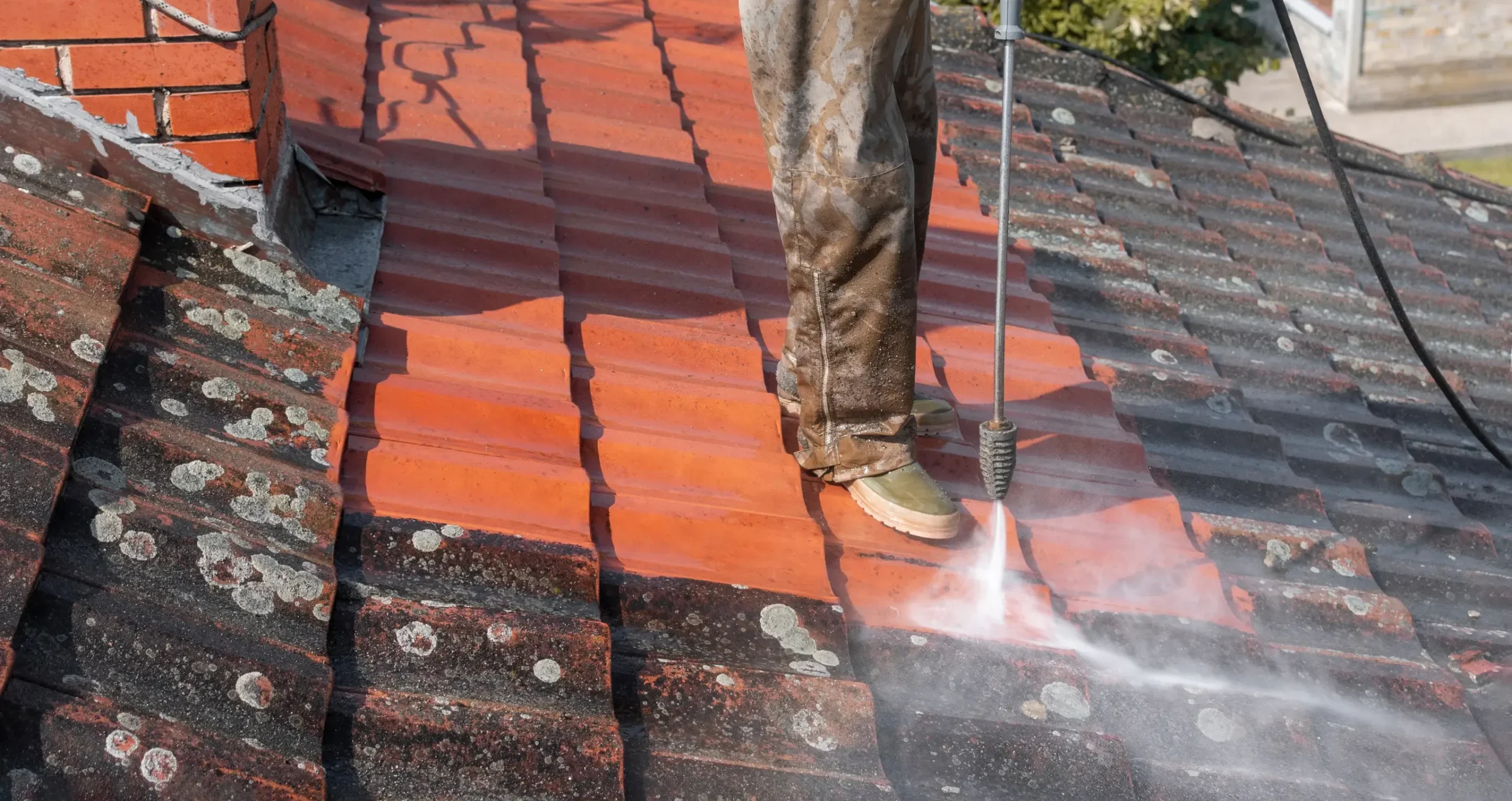 Professional roof washing removing dirt and organic buildup from a residential roof by WOW Roofing & Gutters.